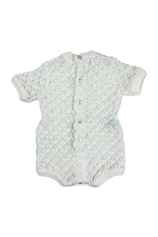Vintage 1960s baby onesie bodysuit of cream crochet knit in a textural layered petal stitch. This beautiful and special piece would be perfect for baby’s layette.

Features a cord tie at the waist, which ties in a bow. The onesie closes in the back with five buttons up the back, and also has snap closures at the bottom.

Designed by Renzo. Made in Italy.
