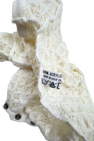 Vintage 1960s baby onesie bodysuit of cream crochet knit in a textural layered petal stitch. This beautiful and special piece would be perfect for baby’s layette.

Features a cord tie at the waist, which ties in a bow. The onesie closes in the back with five buttons up the back, and also has snap closures at the bottom.

Designed by Renzo. Made in Italy.