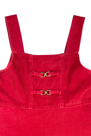 Vintage 1970s girls’ jumper dress in red cotton corduroy with decorative gold buckles across the bodice. Features a classic A-line silhouette with wide shoulder straps.

Designed by Encore. Made in Canada.

85% cotton, 15% polyester.