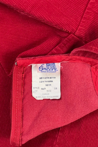 Vintage 1970s girls’ jumper dress in red cotton corduroy with decorative gold buckles across the bodice. Features a classic A-line silhouette with wide shoulder straps.

Designed by Encore. Made in Canada.

85% cotton, 15% polyester.