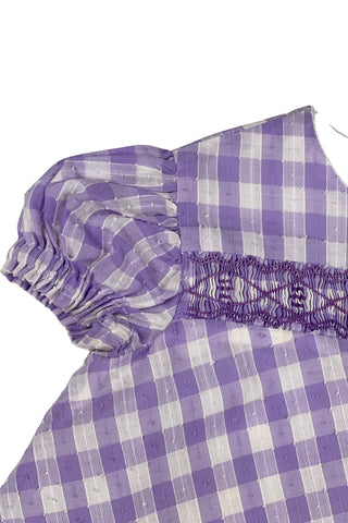 Vintage 1960s smocked baby dress in lilac purple gingham with a dotted texture, similar to Swiss dot. The dress features purple smocking across the chest, and puffed sleeves with elasticized cuffs.

The dress is fully lined, with delicate white lace trim along the hem of the lining. It closes in the back with a cotton twill zipper.