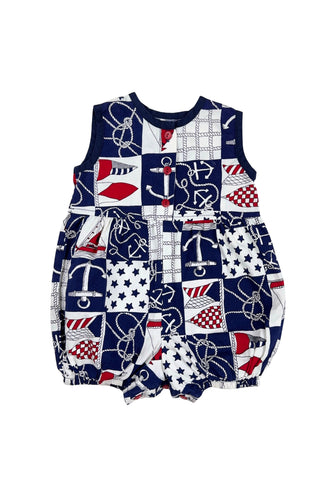 Vintage 1980s baby onesie ‘bubble’ romper in a cotton nautical print. Accented with navy trim around the collar and arm openings, and finished with three red buttons down the chest. Closes with three red buttons on the bottom.