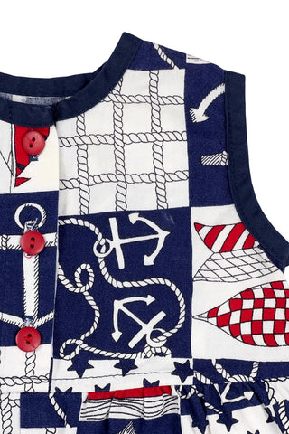 Vintage 1980s baby onesie ‘bubble’ romper in a cotton nautical print. Accented with navy trim around the collar and arm openings, and finished with three red buttons down the chest. Closes with three red buttons on the bottom.