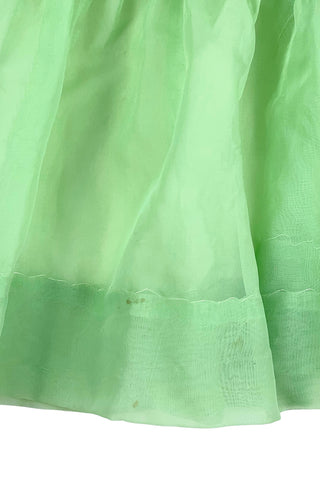 Vintage 1950s smocked baby dress in sheer light green gauze, with pink and white smocking stitching. The dress features a Peter Pan collar, puffed sleeves, and closes in the back with four lucite pink sparkle buttons. The collar and sleeves are trimmed with pink zigzag stitch.

The dress is in good vintage condition, with some areas where the seem has separated, which could be easily fixed.