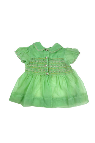 Vintage 1950s smocked baby dress in sheer light green gauze, with pink and white smocking stitching. The dress features a Peter Pan collar, puffed sleeves, and closes in the back with four lucite pink sparkle buttons. The collar and sleeves are trimmed with pink zigzag stitch.

The dress is in good vintage condition, with some areas where the seem has separated, which could be easily fixed.