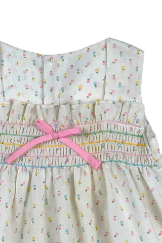 This vintage cotton baby dress is sleeveless and features smocking across the chest, and is accented with a small pink bow. The dress closes in the back with four ivory buttons.

Condition note: There is some light yellow general staining on the chest, but it is very subtle, and could likely be removed with stain treatment.