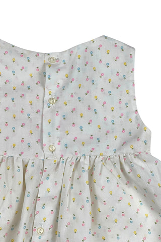 This vintage cotton baby dress is sleeveless and features smocking across the chest, and is accented with a small pink bow. The dress closes in the back with four ivory buttons.

Condition note: There is some light yellow general staining on the chest, but it is very subtle, and could likely be removed with stain treatment.