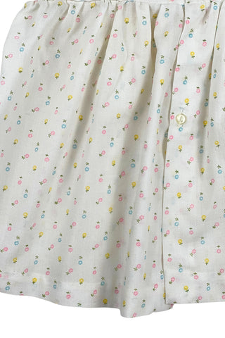 This vintage cotton baby dress is sleeveless and features smocking across the chest, and is accented with a small pink bow. The dress closes in the back with four ivory buttons.

Condition note: There is some light yellow general staining on the chest, but it is very subtle, and could likely be removed with stain treatment.