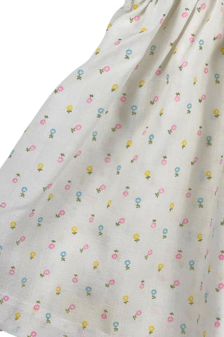 This vintage cotton baby dress is sleeveless and features smocking across the chest, and is accented with a small pink bow. The dress closes in the back with four ivory buttons.

Condition note: There is some light yellow general staining on the chest, but it is very subtle, and could likely be removed with stain treatment.