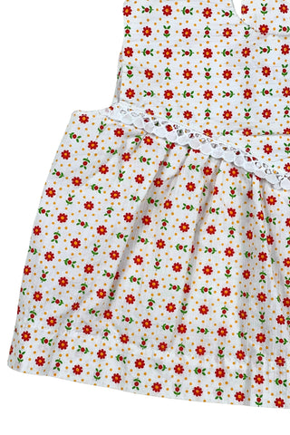Vintage 1960s toddler girls’ white sleeveless dress featuring a red, yellow, and green floral pattern with white eyelet lace trim.

Made in Austria.