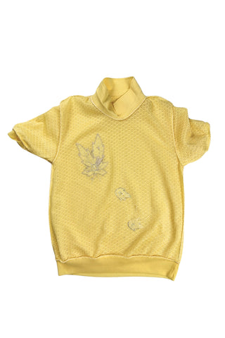 Vintage 1980s short sleeve sweater with ribbed collar and cuffs in sunny yellow tiny eyelet knit with a white leaf appliqué accented with a rhinestone center.