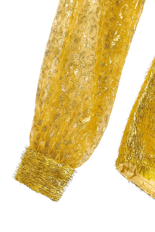 Vintage 1960s gold fringe bodysuit costume with long cuffed sheer lace sleeves and a sweetheart neckline. The hourglass cut of the non-stretch gold material keeps all your curves in place in a classic bombshell shape.

The costume closes in the back with a long cotton twill zipper. There is no opening at the bottom. The long sleeves close with hook and eye closures instead of buttons.
