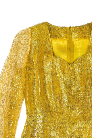 Vintage 1960s gold fringe bodysuit costume with long cuffed sheer lace sleeves and a sweetheart neckline. The hourglass cut of the non-stretch gold material keeps all your curves in place in a classic bombshell shape.

The costume closes in the back with a long cotton twill zipper. There is no opening at the bottom. The long sleeves close with hook and eye closures instead of buttons.