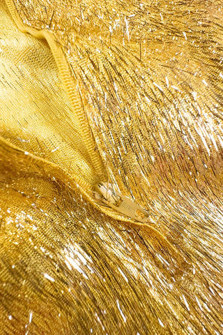 Vintage 1960s gold fringe bodysuit costume with long cuffed sheer lace sleeves and a sweetheart neckline. The hourglass cut of the non-stretch gold material keeps all your curves in place in a classic bombshell shape.

The costume closes in the back with a long cotton twill zipper. There is no opening at the bottom. The long sleeves close with hook and eye closures instead of buttons.