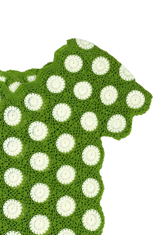 Vintage 1960s crochet sweater top in avocado green with white daisy polkadot pattern. The sweater features a scalloped V-neckline, short sleeves, and a scalloped, pointed hem.
