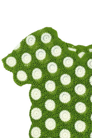 Vintage 1960s crochet sweater top in avocado green with white daisy polkadot pattern. The sweater features a scalloped V-neckline, short sleeves, and a scalloped, pointed hem.