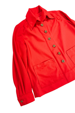 Vintage 1970s tomato red button down shirt, with a pointed collar, long sleeves, and two square patch pockets. The shirt closes with six gold textured buttons down the front, and two matching smaller buttons at the sleeve cuffs.
