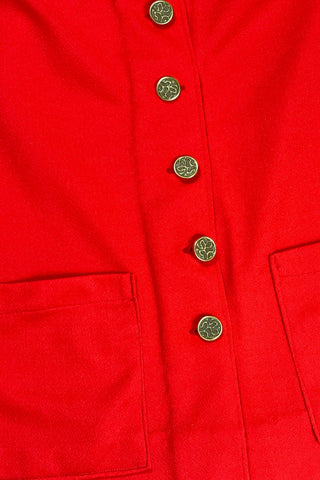 Vintage 1970s tomato red button down shirt, with a pointed collar, long sleeves, and two square patch pockets. The shirt closes with six gold textured buttons down the front, and two matching smaller buttons at the sleeve cuffs.