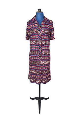 Vintage 1970s day dress with short sleeves and button closure front in a bold blue, yellow, and red ‘crazy’ print with a mixture of floral, stripes and plaid patterns.
The dress closes in the front with four rounded navy lucite buttons, and is unlined.