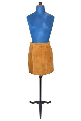 Vintage 1980s suede mini skirt in a light caramel brown colour. The skirt is constructed with a middle panel down the front, and darts in the back to add shape. The skirt closes in the back with a zipper and a snap closure at the waist, and is fully lined.