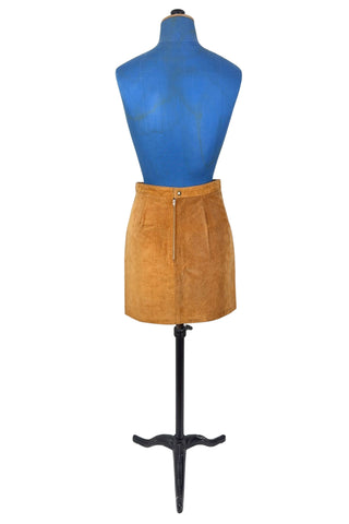 Vintage 1980s suede mini skirt in a light caramel brown colour. The skirt is constructed with a middle panel down the front, and darts in the back to add shape. The skirt closes in the back with a zipper and a snap closure at the waist, and is fully lined.