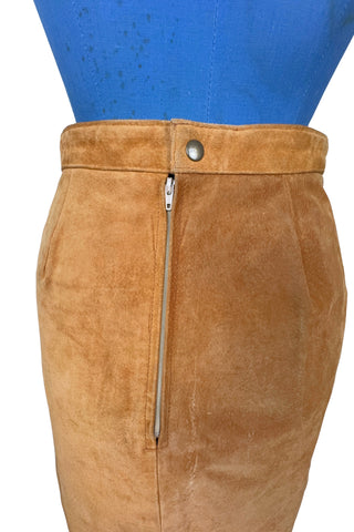 Vintage 1980s suede mini skirt in a light caramel brown colour. The skirt is constructed with a middle panel down the front, and darts in the back to add shape. The skirt closes in the back with a zipper and a snap closure at the waist, and is fully lined.