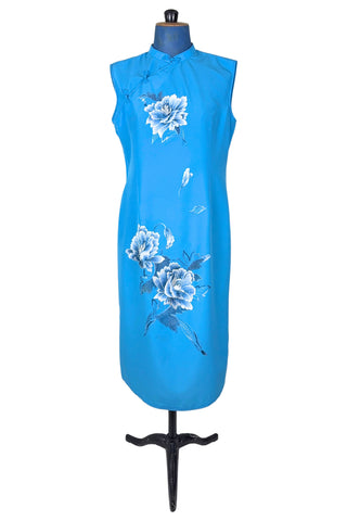 Vintage 1980s cheongsam dress in peacock blue with large white peony flower embroidery. The dress is sleeveless, with a mandarin collar, and closes with three frog closures across the chest, and a side zipper. The dress is unlined.