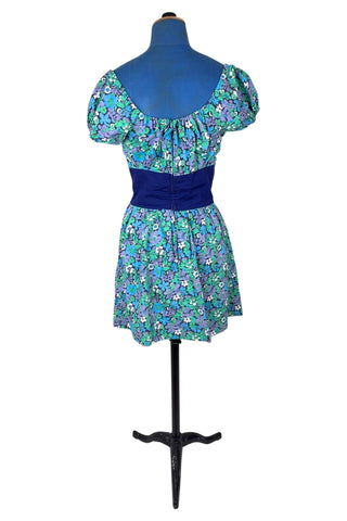 Vintage 1960s mini dress with laced bodice inspired by Alpine dirndl. The dress features a wide gathered neckline and puff sleeves, and closes in the back with a cotton twill zipper. It is made from green and blue floral print cotton with a wide navy blue bodice with silver crest buttons. The dress is unlined.