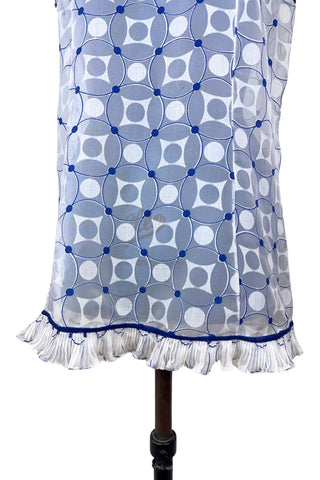 Vintage 1960s babydoll nightie in white and navy blue geometric ‘flowering snowball’ pattern. The white and blue pattern is printed onto sheer white chiffon, creating a 3D effect. The nightie has a wide round collar finished with navy blue piping, which is echoed at the hem and along the edges of the cap sleeves. The hem and sleeves are trimmed with delicate accordion pleated frills.
