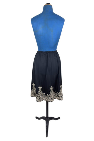 Vintage 1950s half slip in black with intricate cream corded lace decoration at the hem. The waist is elasticized.