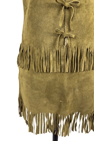 Vintage 1960s fringed suede vest and miniskirt set in olive green suede leather. The vest closes with four ties laced through holes in both sides of the vest. The skirt has open lacing on both hips, with matching suede ties.