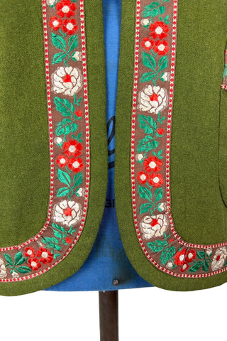 Vintage Trachten-style green wool folk vest featuring floral embroidery trim and a closing tab which fastens with a snap.