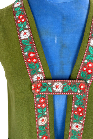 Vintage Trachten-style green wool folk vest featuring floral embroidery trim and a closing tab which fastens with a snap.