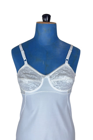 Vintage 1960s full slip with built-in bra. Designed as a close fitting foundation garment which provides a smoothing effect. The front and back panels of the skirt are made of 100% nylon, which gives more sturdy support, while the side panels and bra band have a nylon-spandex blend with more stretch to hug your curves.

Marked size 32 B.
