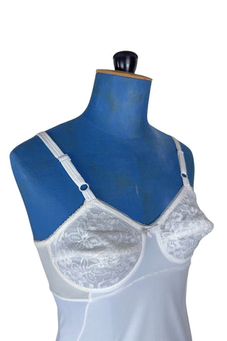 Vintage 1960s full slip with built-in bra. Designed as a close fitting foundation garment which provides a smoothing effect. The front and back panels of the skirt are made of 100% nylon, which gives more sturdy support, while the side panels and bra band have a nylon-spandex blend with more stretch to hug your curves.

Marked size 32 B.