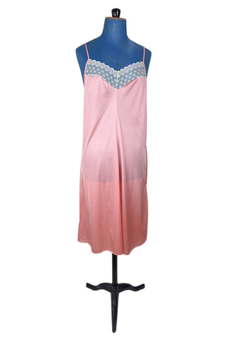 Vintage 1970s nightgown in light pink nylon jersey with wide white lace panel at the V-neckline.
By Claudel. Made in Canada.