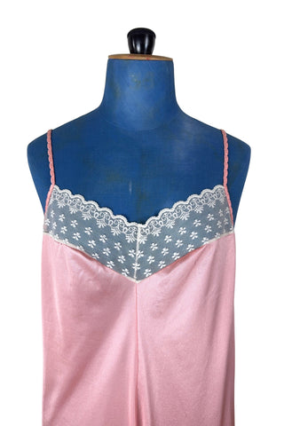 Vintage 1970s nightgown in light pink nylon jersey with wide white lace panel at the V-neckline.
By Claudel. Made in Canada.