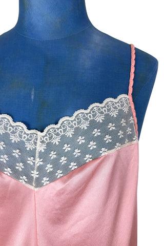 Vintage 1970s nightgown in light pink nylon jersey with wide white lace panel at the V-neckline.
By Claudel. Made in Canada.