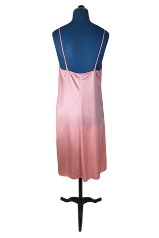 Vintage 1970s nightgown in light pink nylon jersey with wide white lace panel at the V-neckline.
By Claudel. Made in Canada.