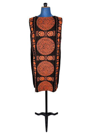 Vintage 1960s cotton shift dress with black and orange Aztec sun stone (calendar stone) woven motif. Straight, easy classic shift fit, with slight shaping from darts at the bust. The dress has no zipper or other closures, and is unlined.