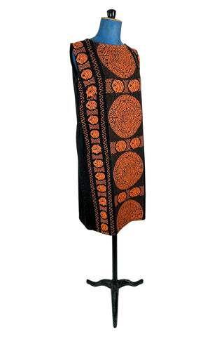 Vintage 1960s cotton shift dress with black and orange Aztec sun stone (calendar stone) woven motif. Straight, easy classic shift fit, with slight shaping from darts at the bust. The dress has no zipper or other closures, and is unlined.