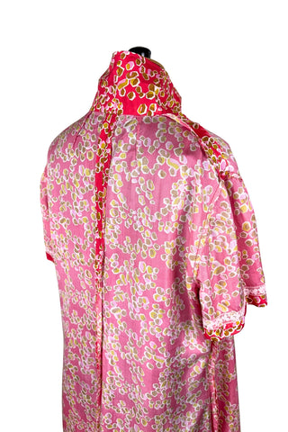 Vintage 1970s silk day dress in abstract ‘pebble’ print in shades of brown and pink on a pinkish red background. The dress has short sleeves, a wide pointed collar, and closes down the front with six flat gold metal buttons.