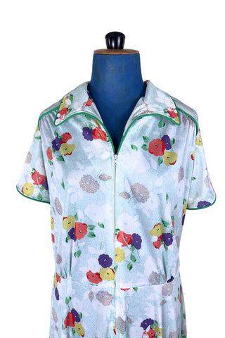 Vintage 1970s house dress in sky blue nylon jersey with a multicolour floral pansy print in red, yellow, purple, and white. The short sleeves and pointed collar are trimmed with grass green piping. Closes with a zipper down the front.

Designed by Windsor.