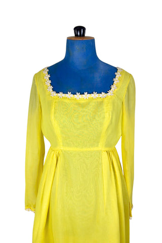 Vintage 1960s yellow empire waist dress with square neckline trimmed with daisy chain lace. Made from fine, semi-sheer cotton muslin, the long sleeves are unlined, while the bodice and skirt have a matching yellow acetate lining. The dress closes in the back with a cotton twill zipper.

Designed by David E. Rea Dresses Limited. Made in Canada.