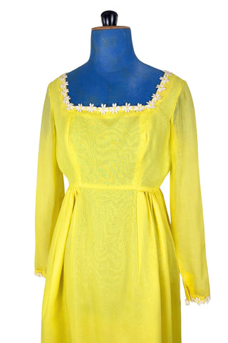 Vintage 1960s yellow empire waist dress with square neckline trimmed with daisy chain lace. Made from fine, semi-sheer cotton muslin, the long sleeves are unlined, while the bodice and skirt have a matching yellow acetate lining. The dress closes in the back with a cotton twill zipper.

Designed by David E. Rea Dresses Limited. Made in Canada.