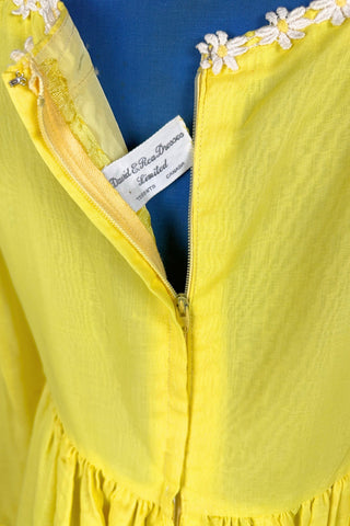 Vintage 1960s yellow empire waist dress with square neckline trimmed with daisy chain lace. Made from fine, semi-sheer cotton muslin, the long sleeves are unlined, while the bodice and skirt have a matching yellow acetate lining. The dress closes in the back with a cotton twill zipper.

Designed by David E. Rea Dresses Limited. Made in Canada.