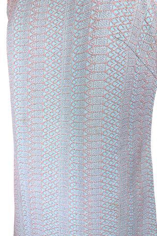 Simple and elegant vintage 1960s shift dress in light blue with a raised silver textured geometric pattern resembling fish or lizard scales. The sleeveless dress features a round collar and darts at the bust to add shape. The dress closes in the back with a cotton twill zipper, and is unlined.

This dress was made from a Vogue pattern, which would have included a Vogue Couturier Design label in the pattern package, intended to be added to the garment after sewing it from the pattern at home.