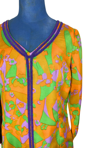 Vintage 1960s psychedelic print maxi dress in bright orange, green and purple abstract floral print, with purple soutache trim detail around the collar and down the front. The dress has long sleeves, and closes in the back with a metal zipper. 

Designed with an A-line silhouette which flares gently through the hips.