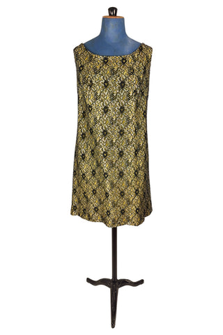 Vintage 1960s cocktail dress with sheer black lace layered over a bright yellow lining. The dress is sleeveless, with straps that narrow towards the back, and a wide, round neckline. Closes in the back with a cotton twill zipper.