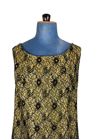 Vintage 1960s cocktail dress with sheer black lace layered over a bright yellow lining. The dress is sleeveless, with straps that narrow towards the back, and a wide, round neckline. Closes in the back with a cotton twill zipper.
